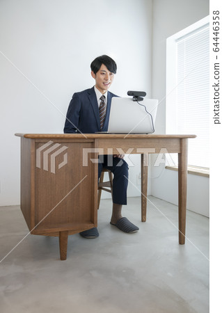 一個年輕人前往一台帶有網絡攝像頭在線採訪視頻聊天圖像的筆記本電腦 一個年輕人前往一台帶有網絡攝像頭在線採訪視頻聊天圖像的筆記本電腦 64446358