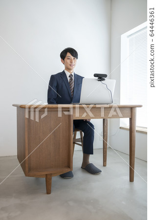 一個年輕人前往一台帶有網絡攝像頭在線採訪視頻聊天圖像的筆記本電腦 一個年輕人前往一台帶有網絡攝像頭在線採訪視頻聊天圖像的筆記本電腦 64446361