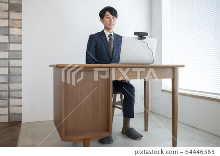 Online interview image A young man heading to a laptop with a webcam Online interview image A young man heading to a laptop with a webcam 64446363