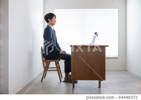 A young man heading for a laptop with a webcam online interview video chat image A young man heading for a laptop with a webcam online interview video chat image 64446372