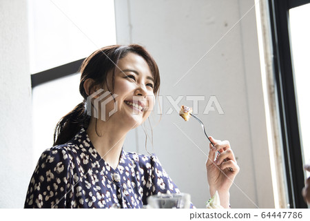 Woman eating pancake 64447786