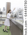 Woman waving from the roof of the building 64449780