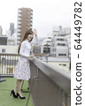 Woman waving from the roof of the building 64449782
