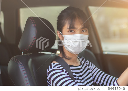 close up face asian young woman driver car wearing medical mask for prevent dust. 64452040