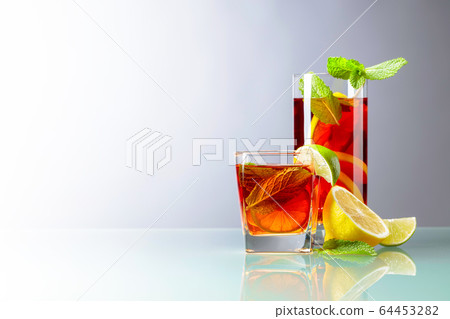 Cold tea with lime, lemon and mint on a glass 64453282