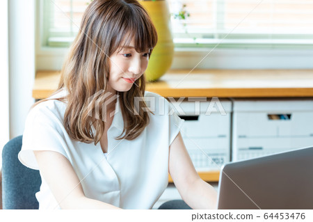 Young woman working in the office Young woman working in the office 64453476
