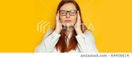 Worker young woman in shirt and eyesight glasses with headache on yellow wall background. Stress, fatigue people concept. Hold hands on head Worker young woman in shirt and eyesight glasses with headache on yellow wall background. Stress, fatigue people concept. Hold hands on head 64456614