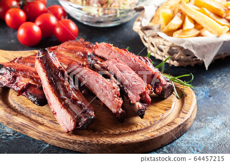 Spicy barbecued pork ribs served with french fries 64457215