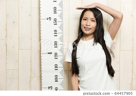 A woman measuring height 64457905