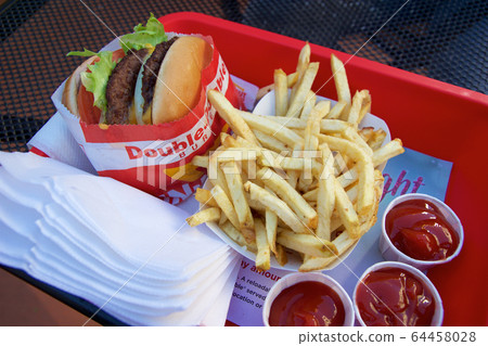 SAN FRANCISCO, CALIFORNIA, UNITED STATES - NOV 25th, 2018: In n Out Double Double cheeseburger with animal style, burger with protein style, and french fries in a tray 64458028