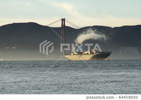 SAN FRANCISCO, CALIFORNIA, UNITED STATES - NOV 25th, 2018: A fast moving cargo container ship, entering San Francisco Bay, sailing underneath the Golden Gate Bridge SAN FRANCISCO, CALIFORNIA, UNITED STATES - NOV 25th, 2018: A fast moving cargo container ship, entering San Francisco Bay, sailing underneath the Golden Gate Bridge 64458050