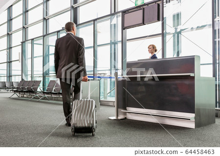 Rear view of mature businessman walking with his 64458463