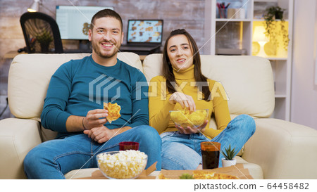 Cheerful bearded man laughing while watching a movie 64458482