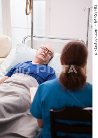 Back view of nurse sitting on chair talking with pensioner Back view of nurse sitting on chair talking with pensioner 64458492