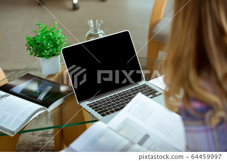 Young woman studying at home during online courses or free information by herself, focus on laptop Young woman studying at home during online courses or free information by herself, focus on laptop 64459997