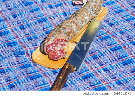 salami on a cutting board during a summer picnic salami on a cutting board during a summer picnic 64461075