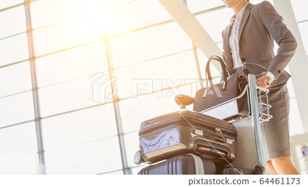 Young attractive businesswoman pushing baggage 64461173