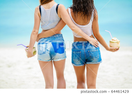 Two girls with coconut cocktails Two girls with coconut cocktails 64461429