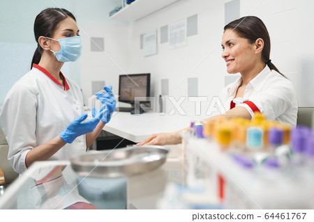 Positive delighted young woman giving sample of blood Positive delighted young woman giving sample of blood 64461767