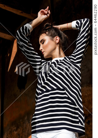 Beauty Fashion Model Girl with Brown Hair on a background of an old, abandoned building, wearing stylish clothes. 64462290