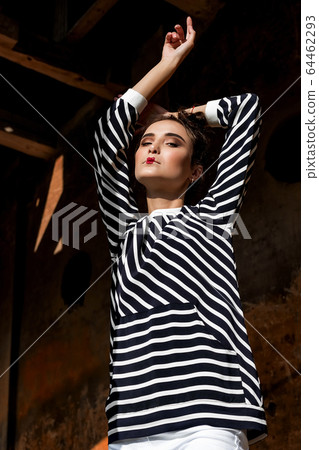 Beauty Fashion Model Girl with Brown Hair on a background of an old, abandoned building, wearing stylish clothes. 64462293
