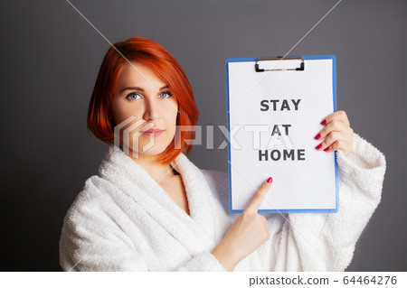 Woman holding blank with inscription stay at home calling for stop spreading covid-19 Woman holding blank with inscription stay at home calling for stop spreading covid-19 64464276