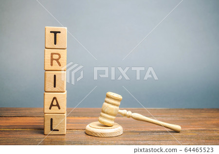 Wooden blocks with the word Trial and hammer of a judge. Settlement of disputes and consideration of criminal cases. Court. Gavel 64465523