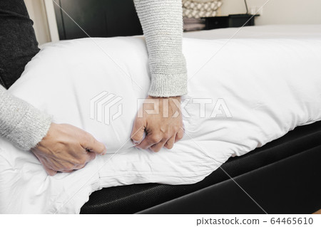 caucasian man making the bed 64465610