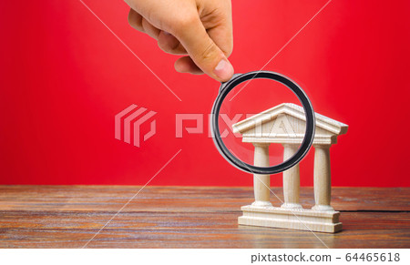 Government or court building on a red background. Building figurine with pillars in antique style. Concept of city administration, bank, university or library. Architectural monument 64465618
