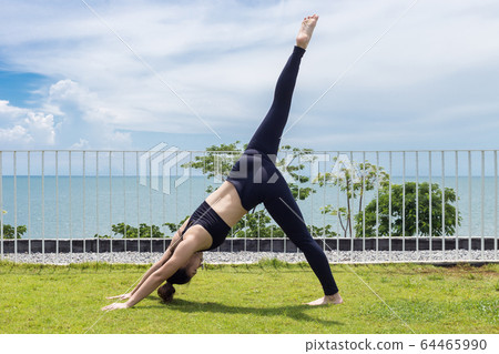 Asian woman relaxing in yoga Seperate leg stretching Pose exercises muscle for warm up on the beach in with seaside,Feeling so comfortable and relax in holiday 64465990