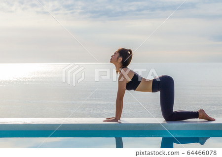 Asian woman practice yoga Cat Pose on the beach in the morning,Feeling so comfortable and relax in holiday,Healthy Concept Asian woman practice yoga Cat Pose on the beach in the morning,Feeling so comfortable and relax in holiday,Healthy Concept 64466078