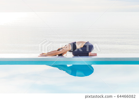 Asian woman practice yoga Child's Pose on the beach in the morning,Feeling so comfortable and relax in holiday,Healthy Concept Asian woman practice yoga Child's Pose on the beach in the morning,Feeling so comfortable and relax in holiday,Healthy Concept 64466082