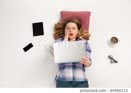Emotional caucasian woman using gadgets isolated on white studio background, technologies connecting people. Crazy shocked Emotional caucasian woman using gadgets isolated on white studio background, technologies connecting people. Crazy shocked 64466113