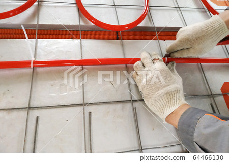 Installation of underfloor heating system, closeup Installation of underfloor heating system, closeup 64466130