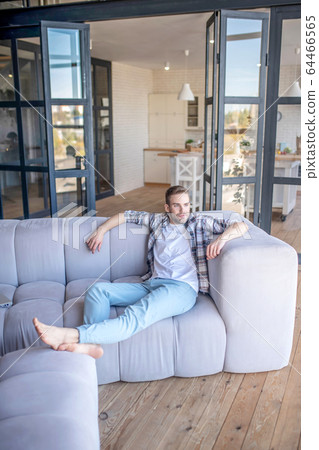 Young man in a checkered shirt looking relaxed Young man in a checkered shirt looking relaxed 64466565
