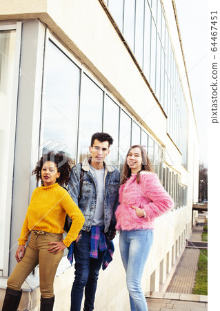 cute group of teenages at the building of university with books huggings, diversity nations real students lifestyle 64467451