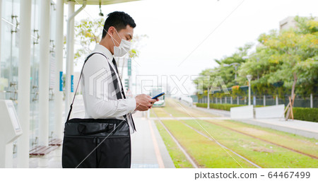 man use smartphone with mask 64467499
