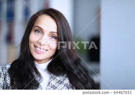 Beautiful young woman in jacket smiles in surprise 64467831