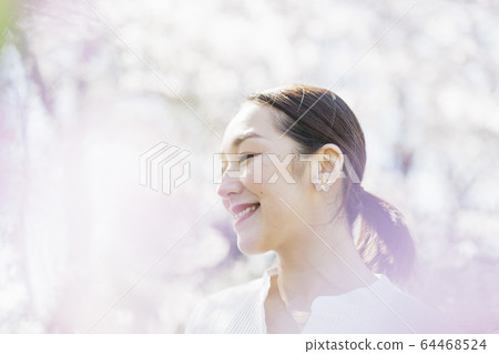 A woman with cherry blossoms in full bloom and oriental beauty 64468524