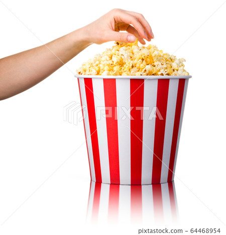 Woman hand picking popcorn from striped bucket isolated on white background Woman hand picking popcorn from striped bucket isolated on white background 64468954