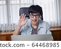 Asian young man  meeting video conference chatting and waving hand hello greeting friend or team  64468985