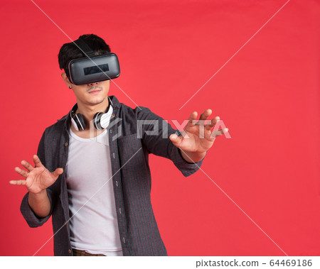 asian man with virtual headset on red background asian man with virtual headset on red background 64469186