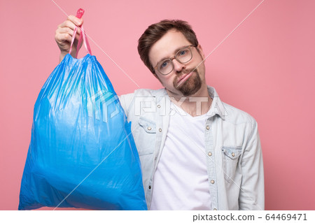 Handsome man holding blue garbage bag isolated on Handsome man holding blue garbage bag isolated on 64469471