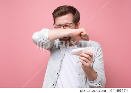 man with handkerchief and glasses sneezing being 64469474