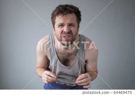 young guy with messy hair squinting gazing 64469479