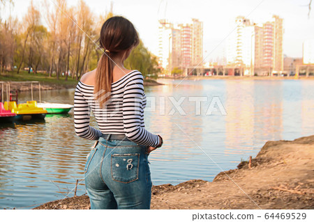 young woman looking over the lake, spring atmosphere young woman looking over the lake, spring atmosphere 64469529