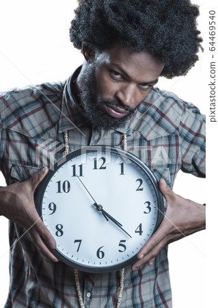 afroamerikaner in a checkered shirt holds the large white clock 64469540