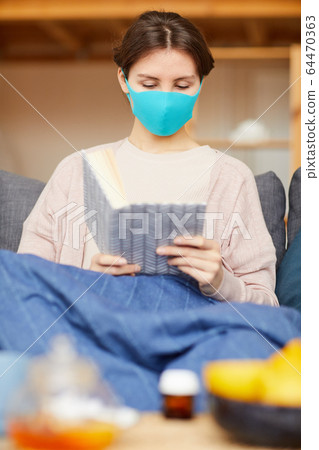 Sick woman reading a book Sick woman reading a book 64470363