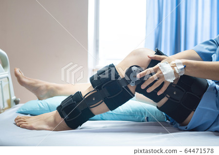 Asian senior or elderly old woman patient with bandage compression knee brace support injury on bed 64471578