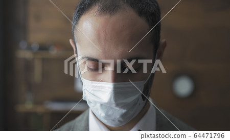 Sad Business Man In Protective Mask Looks Down Sad Business Man In Protective Mask Looks Down 64471796